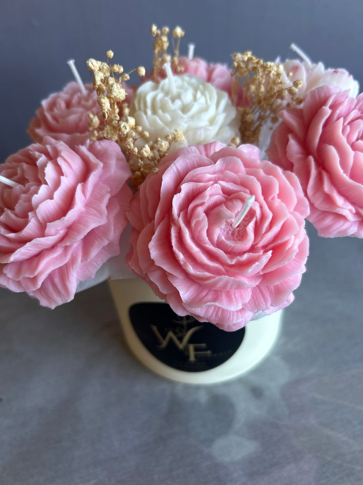 Pink floral arrangement with gold accents on a blurred background