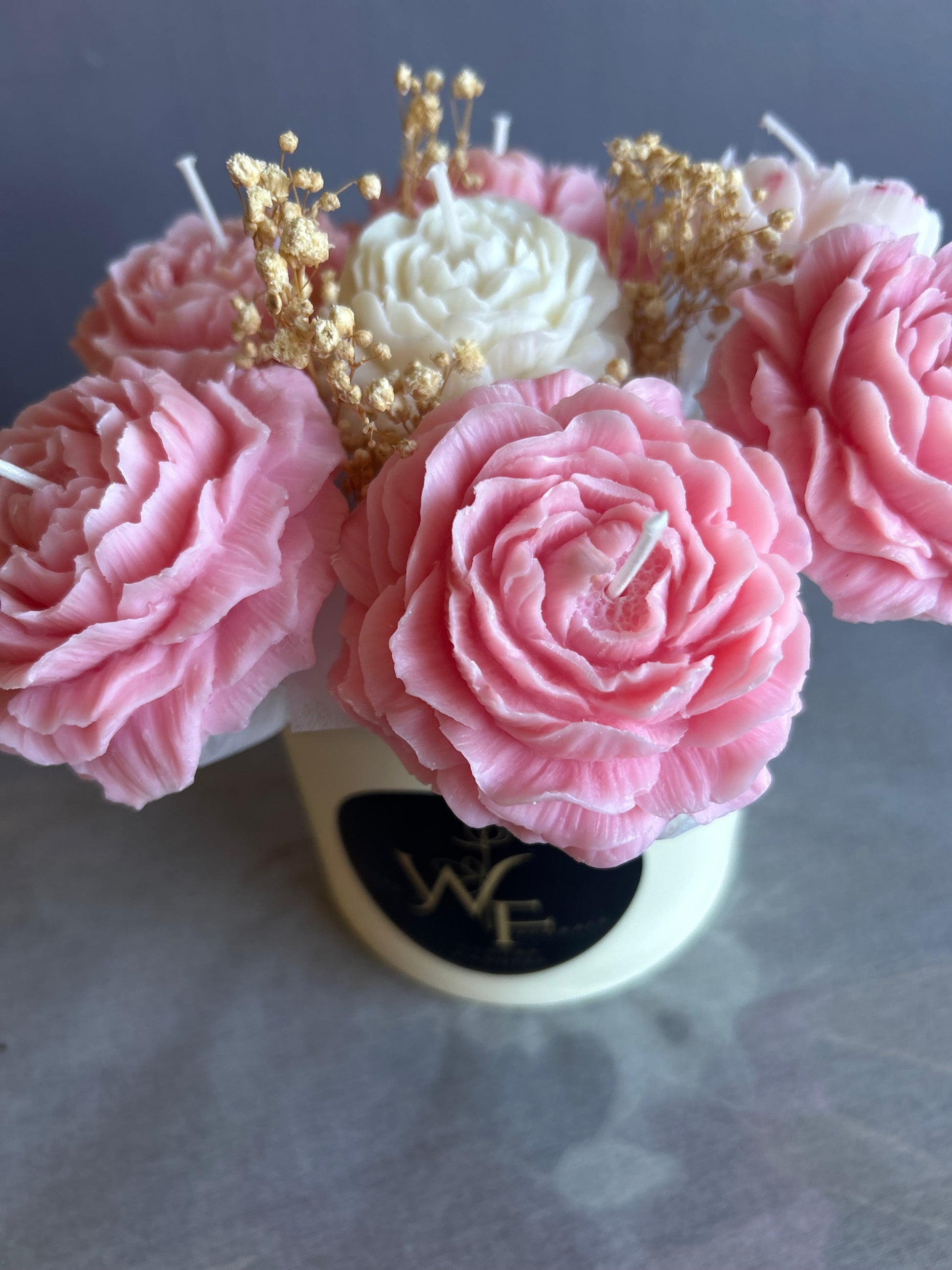 Pink floral arrangement with gold accents on a blurred background