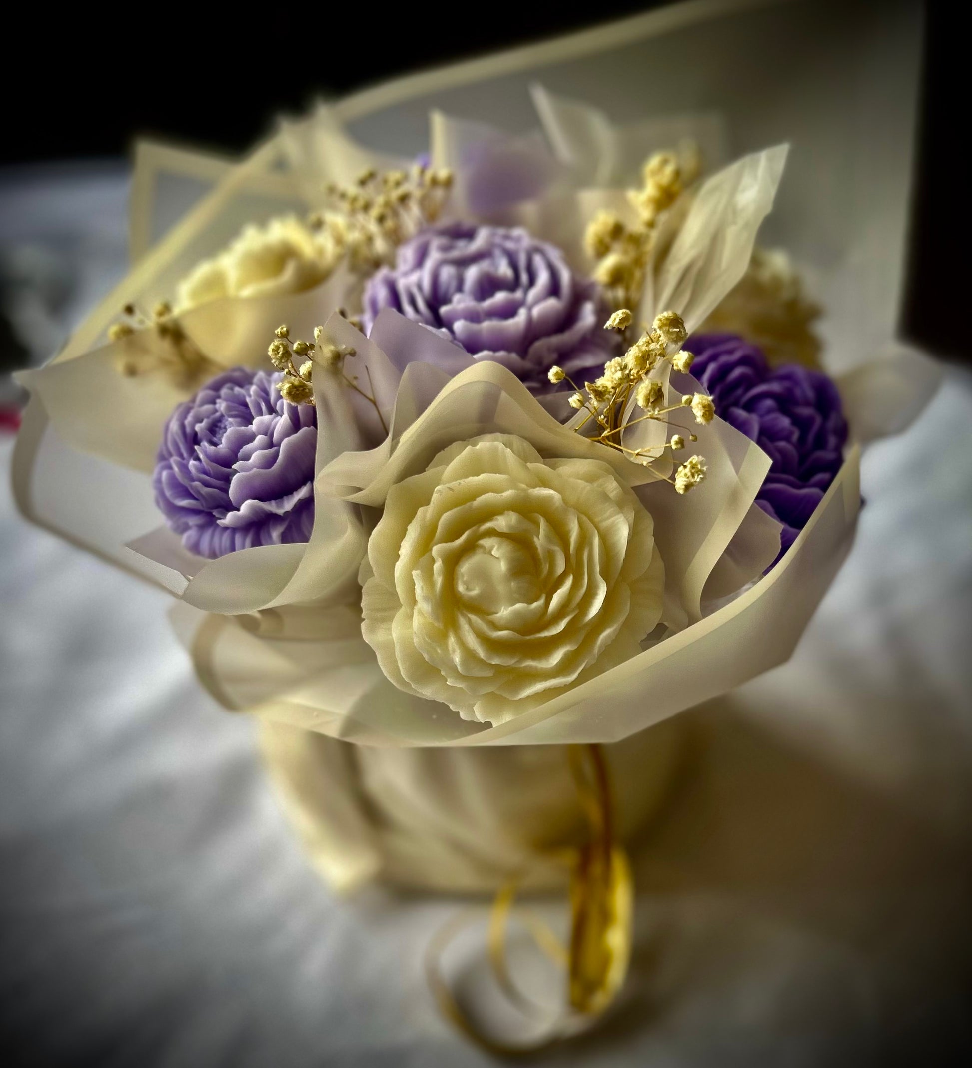 Bouquet of Wax flowers in white, purple, and yellow on a white background